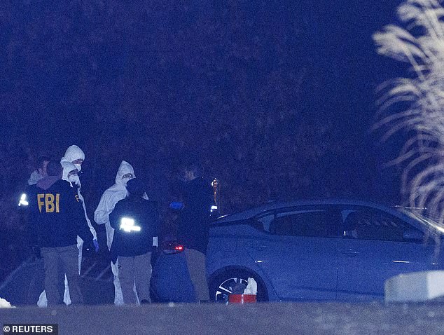 Investigators look at a grey Nissan car at a storage facility where the Brown University shooter, identified by authorities as Claudio Neves Valente, took his own life in Salem, New Hampshire