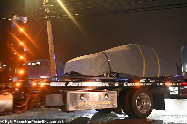 A vehicle is processed by FBI agents at Extra Space Storage and is towed away from the scene with a tarp cover at 10 Hampshire Road in Salem, New Hampshire