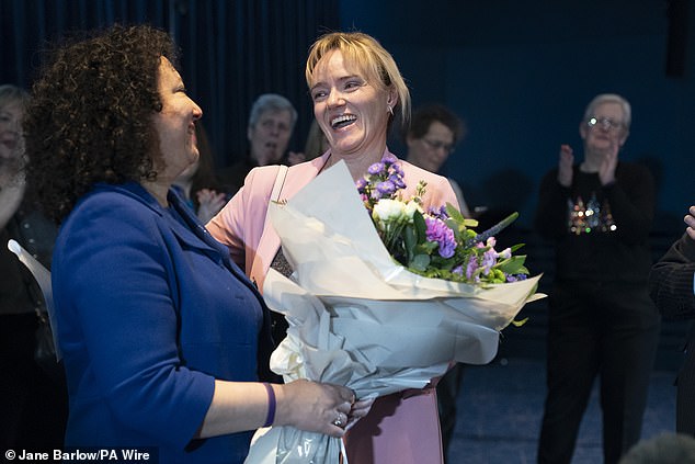 Sandie receives flowers from Maya Forstater who founded Sex Matters to stand up for single sex spaces