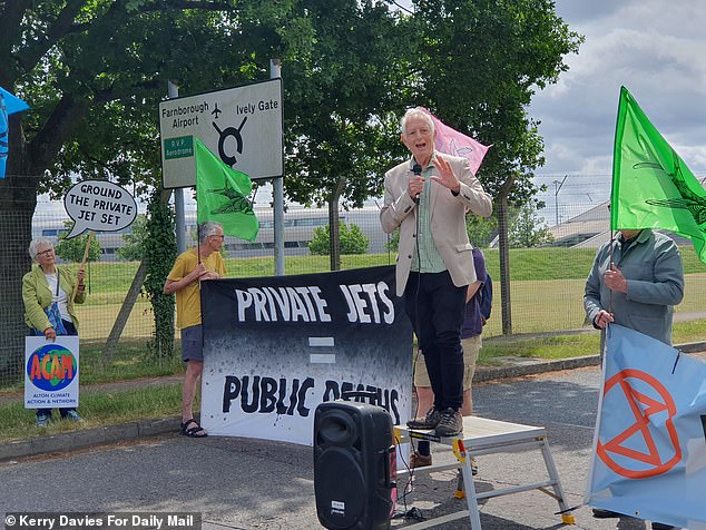 Residents hold banners to protest the airport's request for increased flight numbers