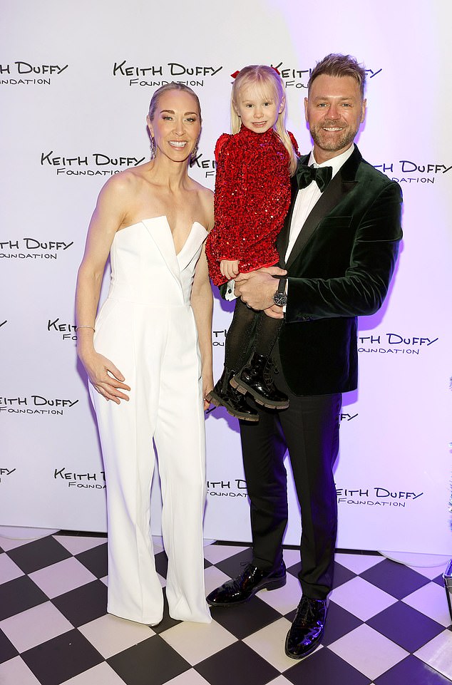 Brian posed with his wife Danielle and their daughter Ruby, who they welcomed back in 2021