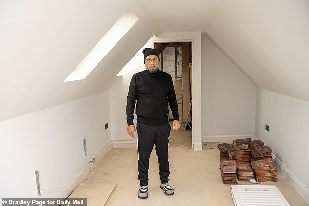 Mr Hussain pictured standing in part of the loft extension for which there was no permission in his initial plans. He later lodged retrospective plans, and says he feels the council is 'bullying' him and other residents in similar situations