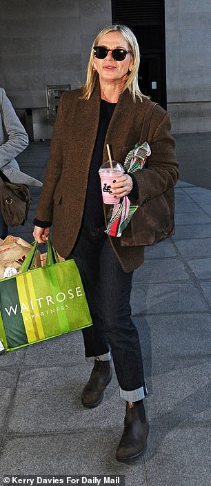 She paired the look with a black sweater and sunglasses