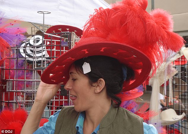 Maxwell poses in an ostentatious red hat with feathers while pulling a suggestive pose