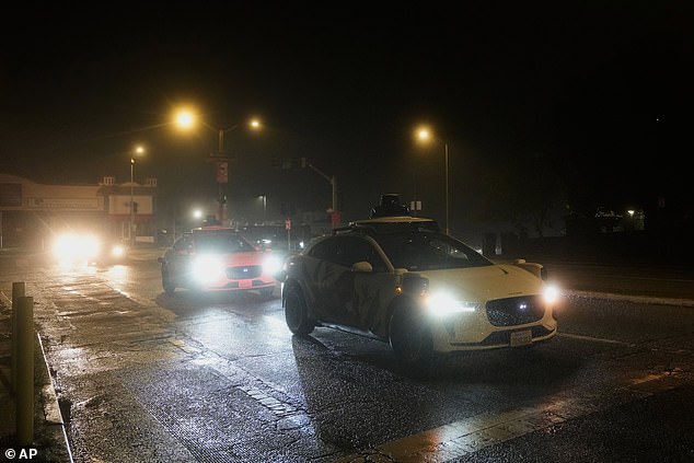 A Waymo vehicle sits idling at an intersection with no operating traffic lights due to power outages, in San Francisco, California on Saturday