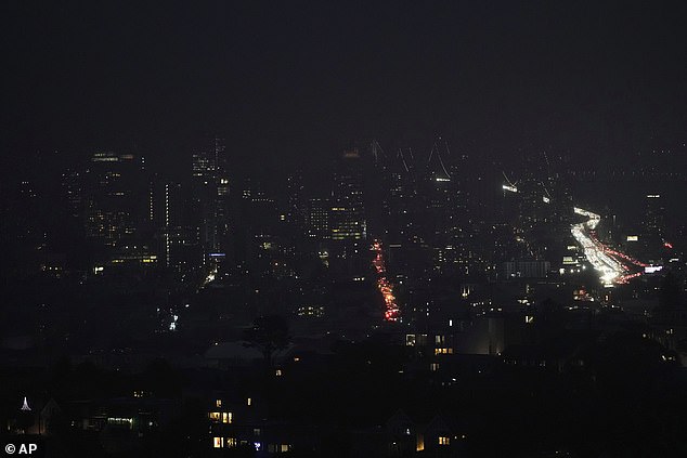 Fog and power outages darken the skyline as traffic moves in dark San Francisco