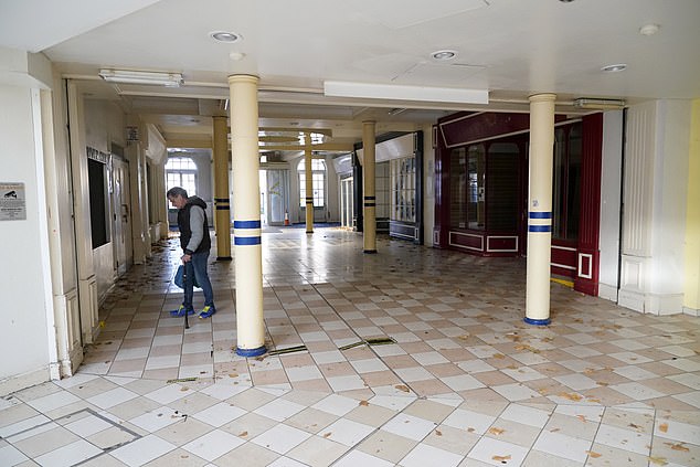 The mall's glass roof leaks so there are buckets and 'Wet Floor' warning signs everywhere and the cafe has been forced to close one of its seating areas due to puddles