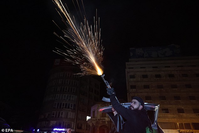 A Syrian rebel fires a weapon into the air to celebrate the rebel takeover of Damascus, in Homs, Syria, early 08 December 2024
