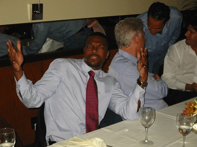 Comedian Chris Tucker poses at a table in one of the images released by the DOJ