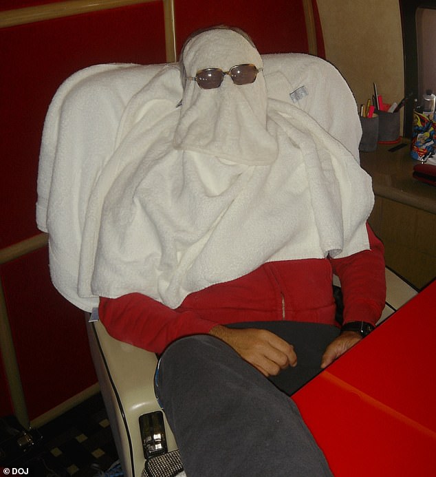 A man, thought to be Epstein is pictured hiding beneath towels with sunglasses over his face