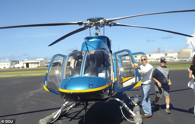 Epstein poses with a blue helicopter at an airfield in a photo released as part of the files