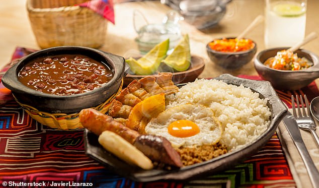 Traditional Colombian dish Bandeja Paisa with fried egg, beans, rice, chorizo, and pork rind