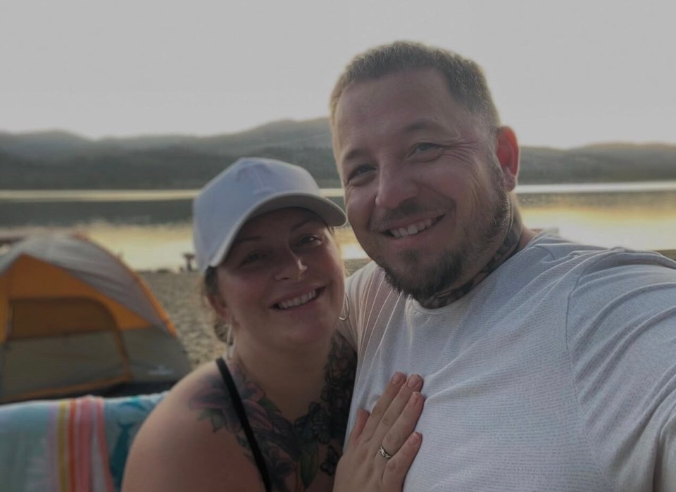 Christopher and Desiree Hart-Spegal smiling outdoors at sunset.