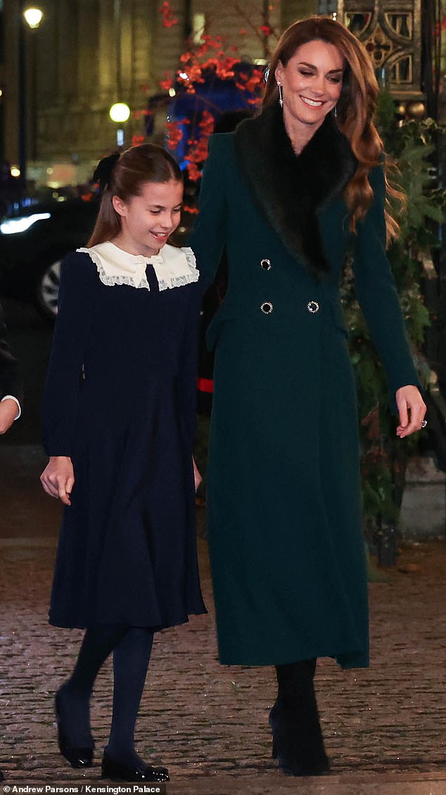 Charlotte, dressed in a navy dress, stayed close to her mother as they entered the event