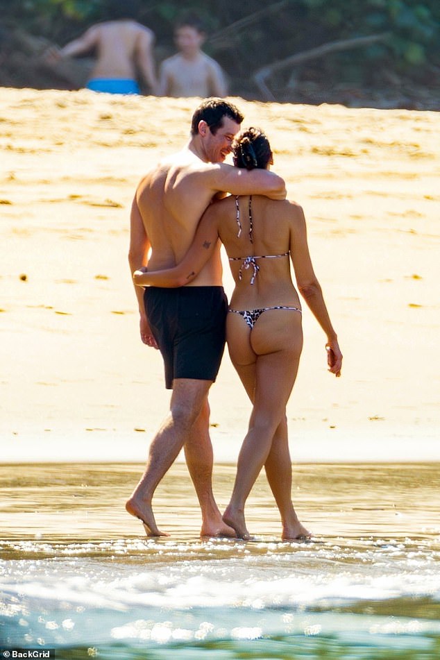 The thong briefs showed off her pert posterior as her and Callum strolled to the water to cool down