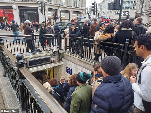 People are seen entering and exiting Oxford Circus Tube station in London on Sunday, December 21