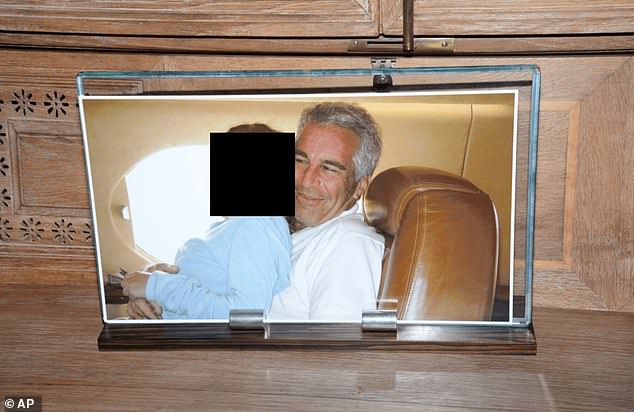 This redacted photo released by the US Department of Justice shows a framed photograph of Jeffrey Epstein with a person on his lap, documented on August 12, 2019, during a search of his home on Little St. James island in the US Virgin Islands