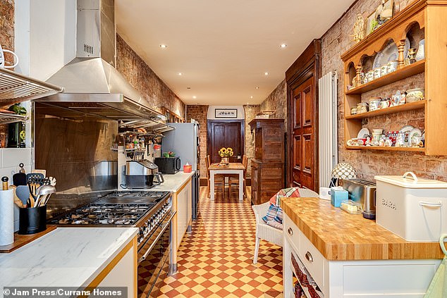 A kitchen-breakfast area sits behind the dining area with beautiful exposed brick walls