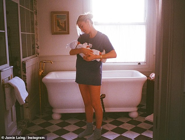 In another candid snap, Sophie, 31, wore a baggy t-shirt as she gazed adoringly down at her newborn in the bathroom of their home