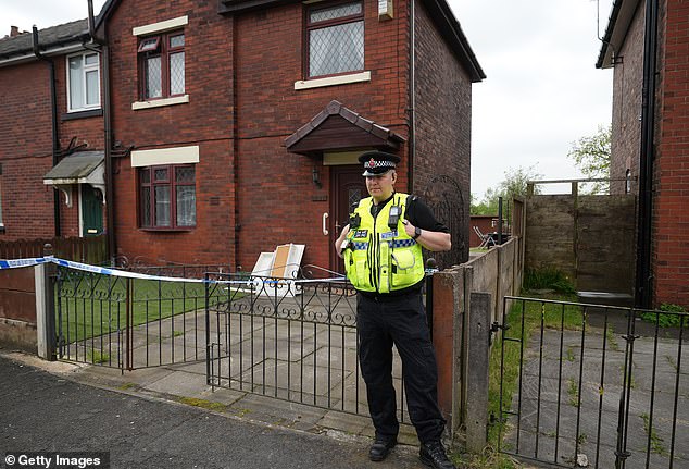 A police officer standing guard outside Walid Saadaoui's house near Wigan after the raids in May 2024