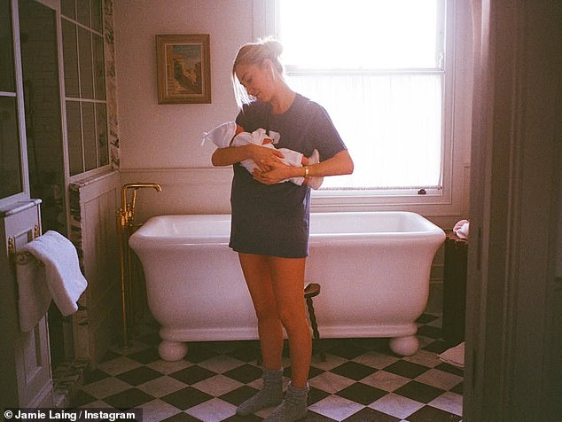 In another candid snap, Sophie, 31, wore a baggy t-shirt as she gazed adoringly down at her newborn in the bathroom of their home