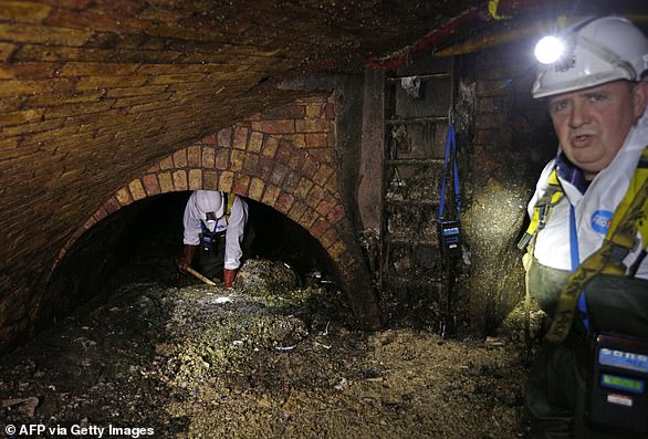 Fatbergs are blockages made up of flushed fat, oil, grease and other flushed waste such as wet wipes and illegal drugs. Pictured: Technicians clear a fatberg beneath Regent Street, London