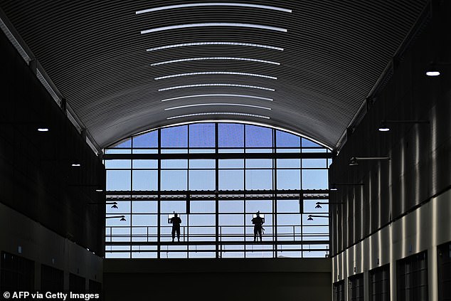 Prison officials stand guard on a pavilion inside the CECOT prison