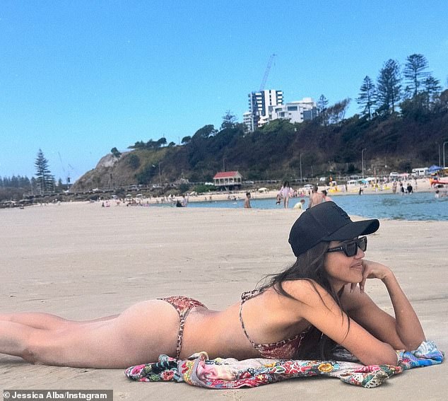 The diva from California was smiling as she sunbathed on the sand while laying on her chic Johnny Was kimono