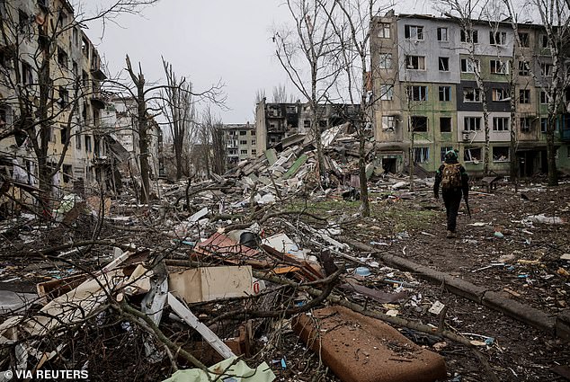 Mr Zelensky said Ukraine would only accept such arrangements if they were approved by a nationwide referendum. Pictured: A Ukrainian serviceman walking near apartment buildings in the country's Donetsk region, which were destroyed after Russian attacks this week