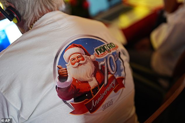 Bill Schwamle of Longmont, Colo., wears a shirt while volunteering to answer calls from people wondering where Santa Claus is on his journey around the globe at a call center Wednesday, Dec. 24, 2025, in NORAD Peterson Space Force Base in Colorado Springs, Colorado