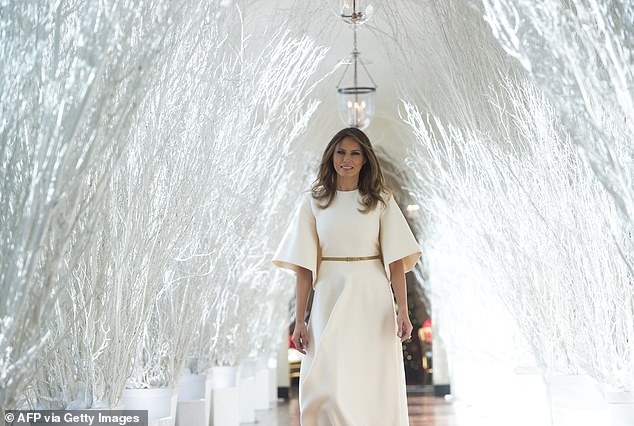US First Lady Melania Trump walks through Christmas decorations in the East Wing as she tours holiday decorations at the White House in Washington, DC, on November 27, 2017