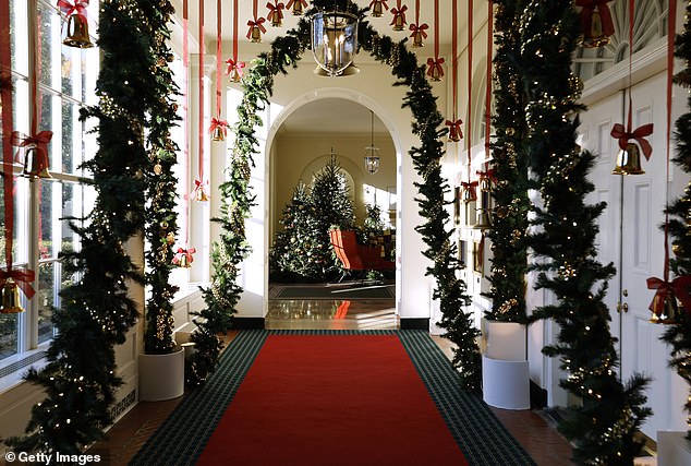 Brass-colored bells hang from the ceiling and sleigh bells line the archways of the East Colonnade during a media preview of the 2024 holiday decorations designed by Jill Biden at the White House on December 02, 2024 in Washington, DC. This photo was the first option presented to poll respondents