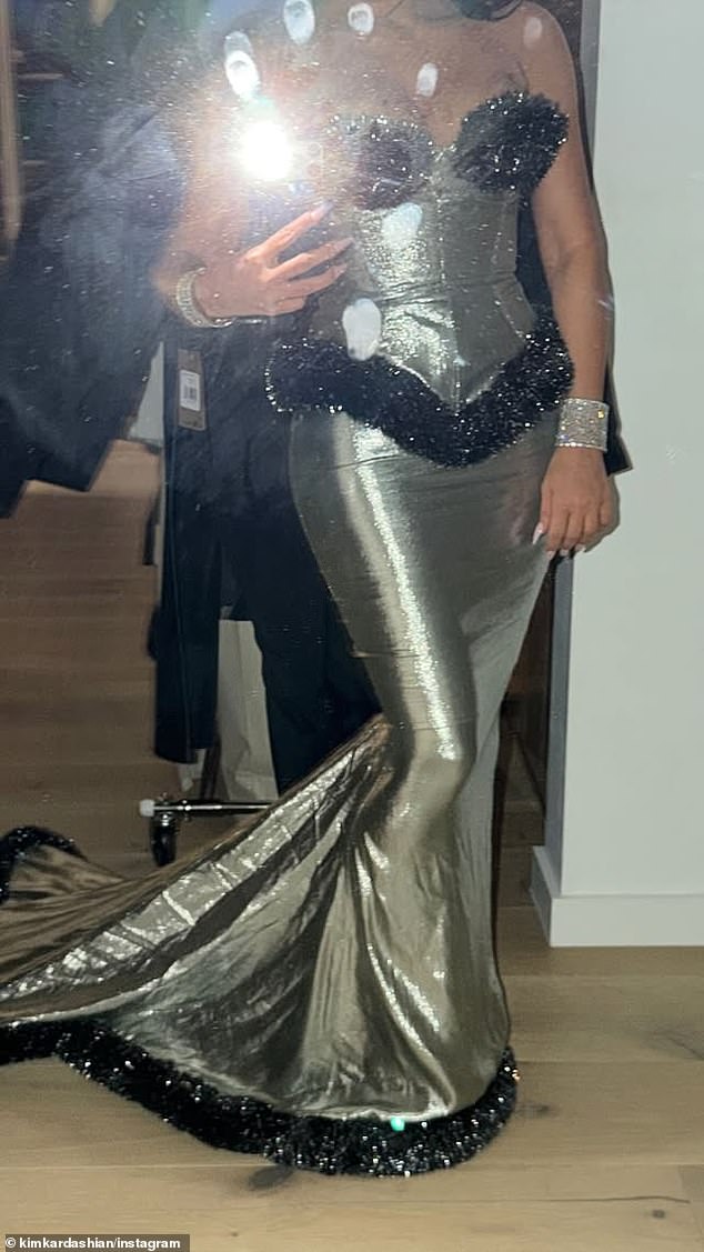 It comprised of a shimmering silver corset top with a matching skirt that clung to her curves and fell down into a train behind her