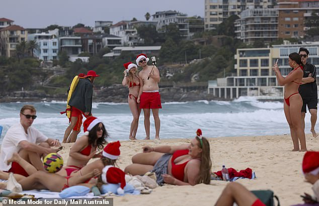 A couple posed for a photo with a selfie stick while other revellers mingled with friends on the sand