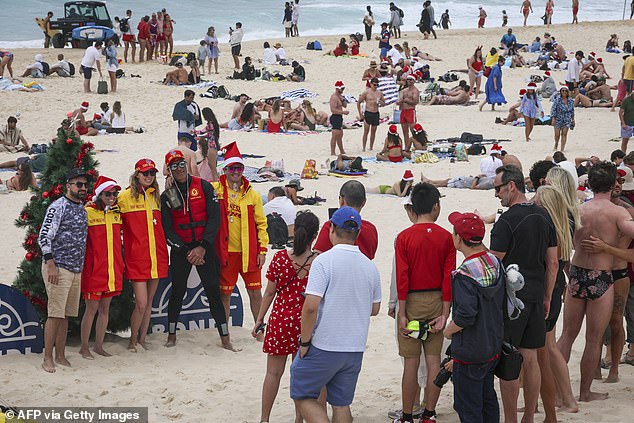 Beachgoers posed with lifesavers in front of a Christmas tree