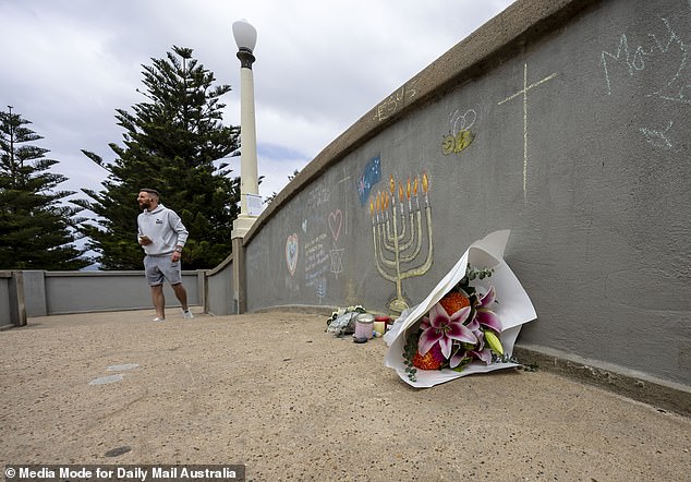 Floral tributes remained on the footbridge as Christmas Day festivities took place on the beach