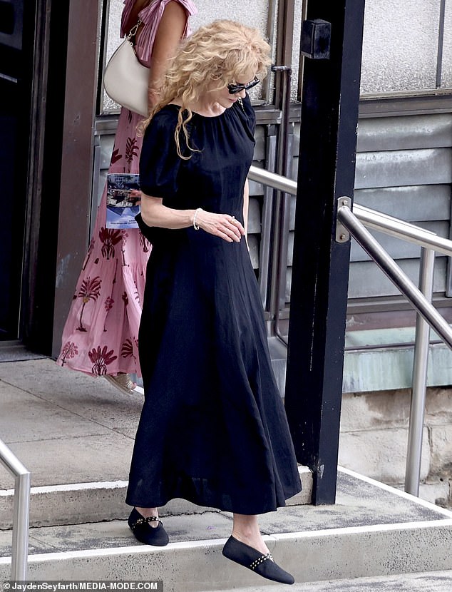 Her naturally curly, perm-like strawberry blonde hair looked effortlessly beautiful, framing her face as she paused outside the church, embodying quiet composure on one of the most significant days of the year