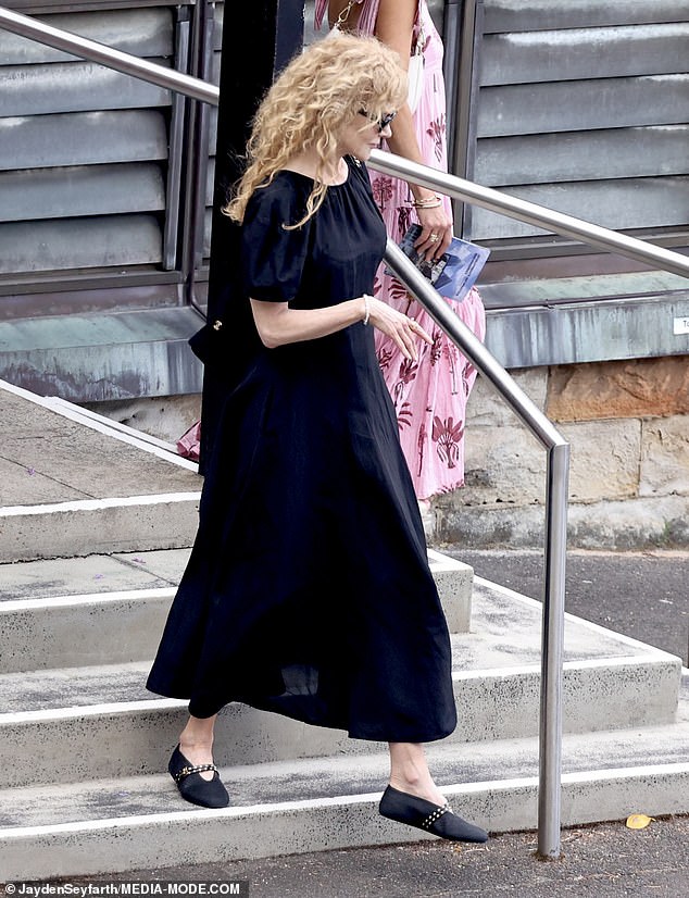 Nicole kept her head slightly bowed as she lingered outside the church, appearing deep in thought before making her way inside for the service