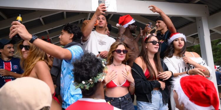 Thousands of revellers flood one of Australia's most popular beaches as backpackers in bikinis celebrate Christmas Day