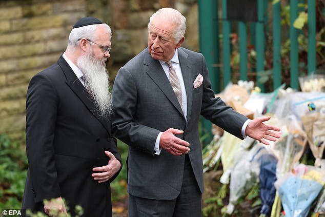 Charles speaks with Rabbi Daniel Walker while looking at floral tributes to victims of the Manchester Heaton Park Hebrew Congregation Synagogue attack