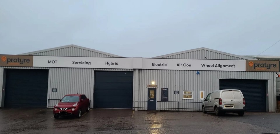 Protyre garage with two bay doors, a red car, and a white van outside, offering MOT, Servicing, Hybrid, Electric, Air Con, and Wheel Alignment.