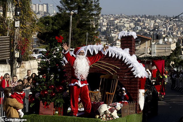 A man wearing Santa Claus costume takes part in the 40th annual Christmas parade heading towards the Basilica of the Annunciation on December 24, 2025 in Nazareth, Israel