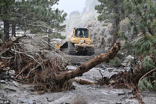 Mud is cleared by tractor after a series of storms on Christmas Day in Wrightwood, California in San Bernardino County