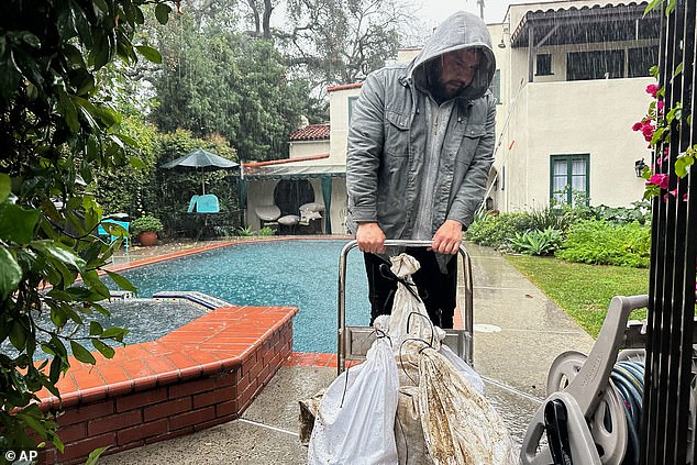 Michael Burdick prepare sandbags around his home in Altadena, California
