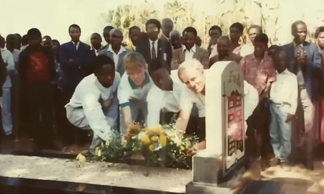 Smyth (left of gravestone) at Guide's grave during the boy's funeral after he was found dead in the pool at Zambesi Holiday Camp in December 1992 after reportedly going swimming naked