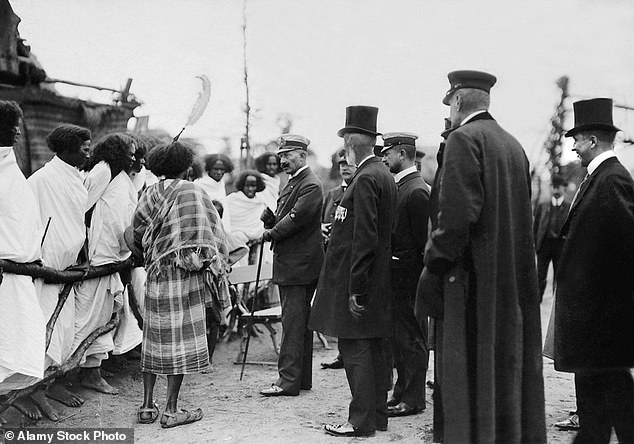 Germany's Kaiser Wilhelm II is pictured meeting Ethiopians standing behind a wooden fence in Hamburg, Germany in 1909