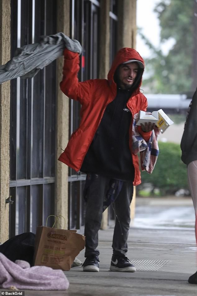 Photos and video obtained by the Daily Mail show a Good Samaritan dropping by to give Chase a red raincoat to protect him from the elements