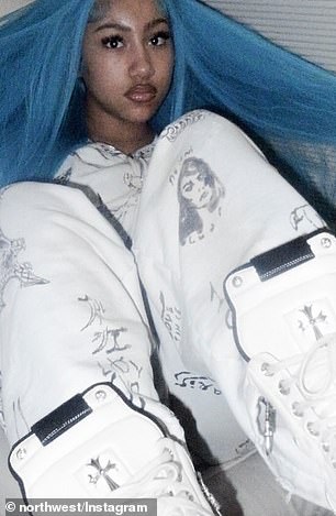 She wore a white sweatsuit covered in black graphic print, completing the look with a pair of white, high top Chrome Hearts sneakers