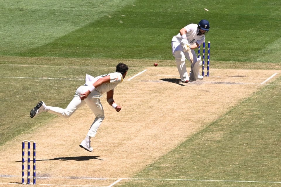 A bowler pitches the ball towards a batsman during a cricket match.