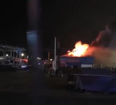 A building at the Ocean Beach Pleasure Park Funfair on fire at night.